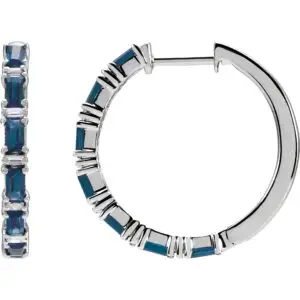 Pair of 14k white gold sapphire hoop earrings, measuring 2 mm thick, with fourteen GIA Type II Clarity AA, round brilliant cut sapphires. The sapphires have a total weight of 1.26 carats, and are prong set. In addition, there are twelve baguette diamonds, G-H color, I1 clarity, with a total weight of 1.25 carats.