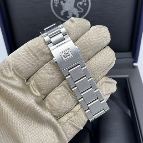 Caseback view of Grand Seiko SBGA427 showing GS-signed clasp and brushed stainless steel bracelet