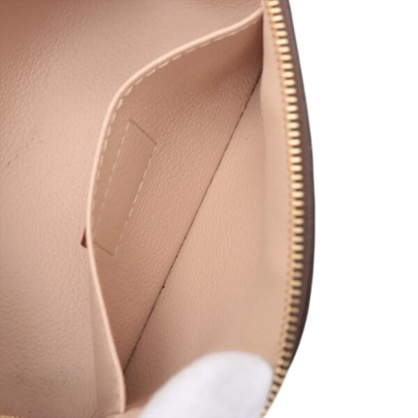 Close-up of the inner side pocket inside the pouch, revealing fine stitching and smooth leather lining.