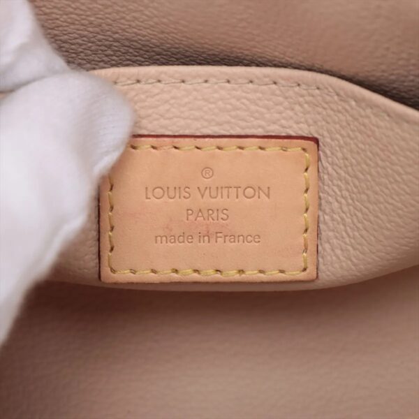 Detail of the interior Louis Vuitton tag stamped “Louis Vuitton Paris Made in France” on natural leather.