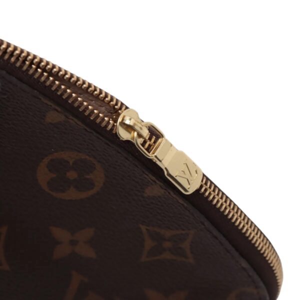 Side angle of the zipper pull and stitching, showing quality hardware and texture of the monogram canvas.