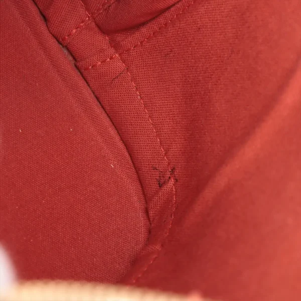 Detailed interior shot of the red fabric lining, highlighting stitching and minor wear marks.