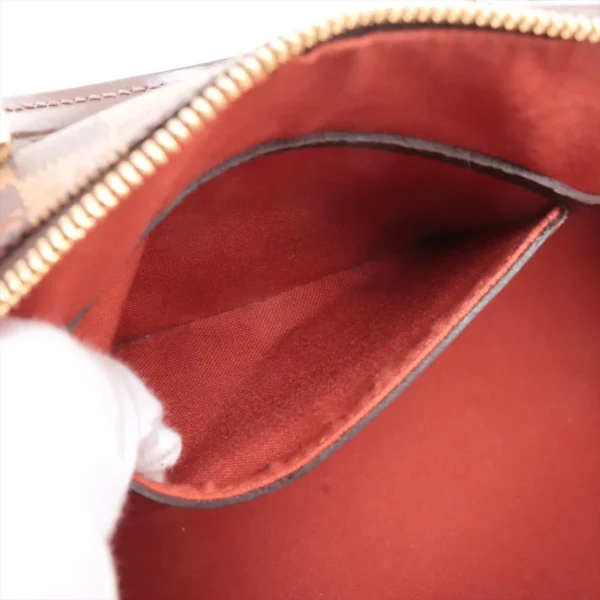 Interior close-up of the bag showing the red textile lining and slip pocket detail.